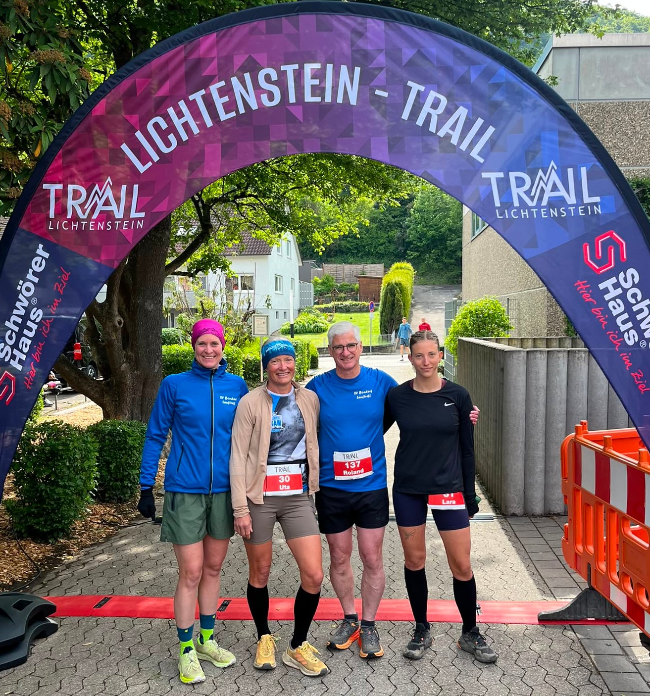  Vier Läufer*innen unter dem Zielbogen des Lichtenstein Trails